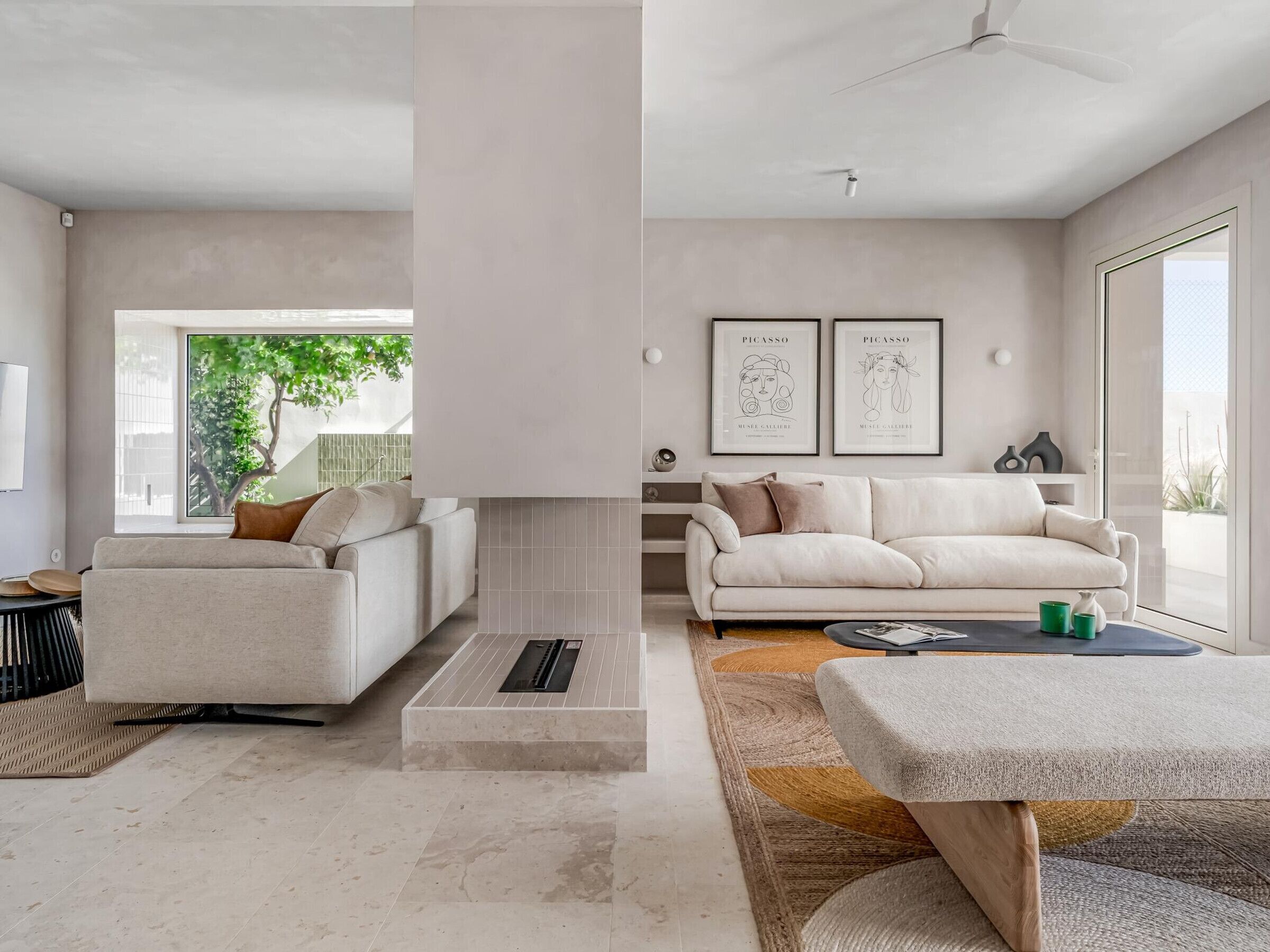 A modern living room with two sofas, a coffee table, and a large window.