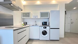 A modern kitchen with a built-in washing machine, a microwave, and a refrigerator. - Central apartment in Málaga - 2 guests (Málaga)