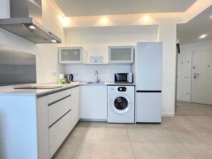 A modern kitchen with a built-in washing machine, a microwave, and a refrigerator. - Central apartment in Málaga - 2 guests (Málaga)