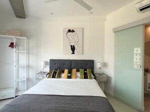A bedroom with a bed, bedside tables, a wardrobe, and a door. - Central apartment in Málaga - 2 guests (Málaga)