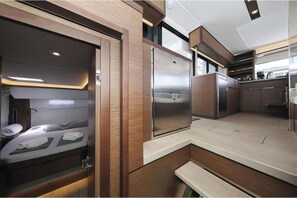 Interior moderno y compacto de una caravana, con una kitchenette, una cama y un pequeño rincón de descanso.