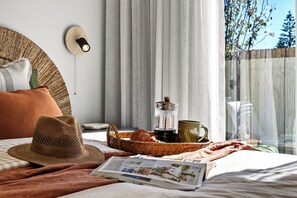 A neatly made bed with a magazine, a hat, and a tray with a coffee pot and mug. - Luxury Bali-Inspired 3BR Villa with Pool in Mosman Park (Mosman Park)