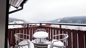 A balcony with a view of a snowy landscape and a red building. - Åre Fjällby (Are)