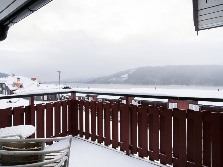 A balcony with a view of a snowy landscape and buildings.