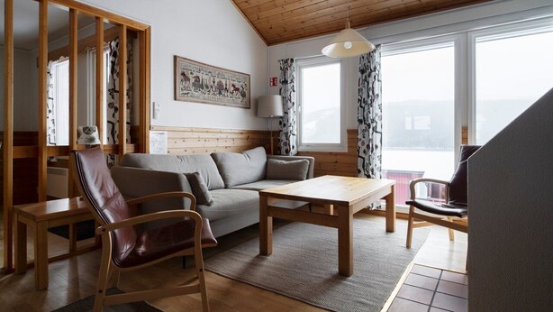 A cozy living room with a sofa, a wooden coffee table, and a leather chair. - Åre Fjällby (Are)