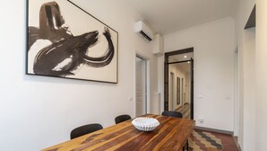 Ein moderner Essbereich mit einem Holztisch, Stühlen und einem großen abstrakten Gemälde an der Wand.