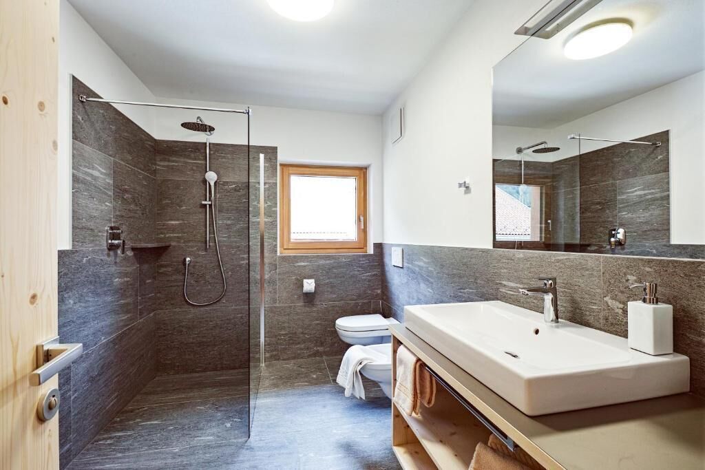 Bathtub, pengering rambut, sandal, dan handuk