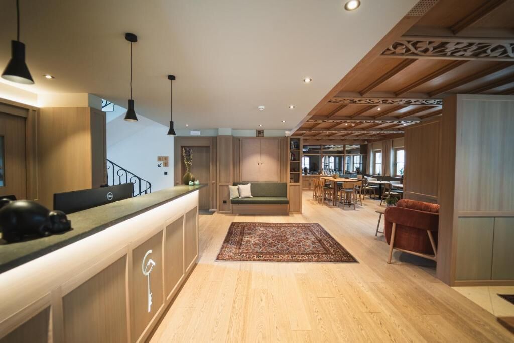 A modern interior with a reception desk, seating area, and dining space.