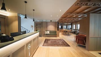 A modern interior with a reception desk, seating area, and dining space.