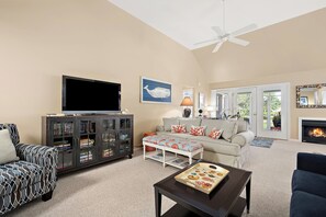 A living room with a television, bookshelf, sofa, and a fireplace. - Pond Front Home with Magnificent Sunset views from the gorgeous Screened porch! (Lewes)
