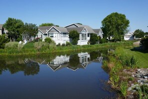 A residential area with houses, a pond, and a clear sky. - Pond Front Home with Magnificent Sunset views from the gorgeous Screened porch! (Lewes)