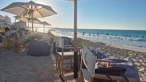 A beachside setting with umbrellas and lounge chairs, a clear view of the ocean, and a sandy beach. - Naya Suites; Luxury 2BR Panoramic Sea & Lagoon View, Beach Towers (Marsa Matrouh)