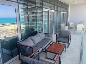 A balcony with a sofa, chairs, and a table. - Naya Suites; Luxury 2BR Panoramic Sea & Lagoon View, Beach Towers (Marsa Matrouh)