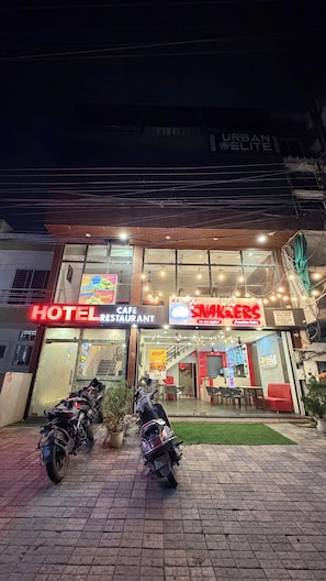 Ein Hotel mit Restaurant und Snackbar. Vor dem Gebäude sind zwei Motorräder abgestellt.