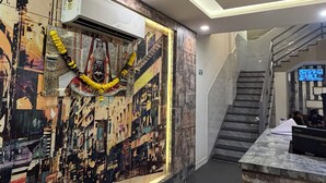 Rebedor d'hotel amb disseny modern, unes escales i una taula de recepció.