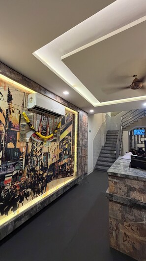 Eine Hotelhalle mit modernem Design, einer Treppe und einem Empfangstresen.