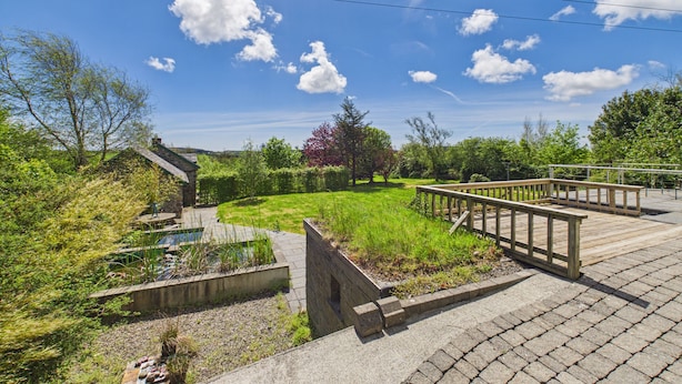 A garden area with a wooden deck, stone walls, and a small pond. - 5 Bedroom Country House in Waterford (Waterford)