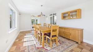 A spacious dining area with a wooden table and chairs, a patterned rug, and a wooden cabinet. - 5 Bedroom Country House in Waterford (Waterford)