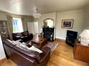 A living room with a fireplace, a television, and a sofa.