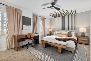 A hotel room with a bed, desk, chair, and a ceiling fan. - 49 North Oasis • Heated Pool • Spa • Mini-Golf • Game Room (Scottsdale)