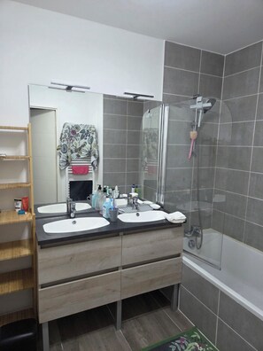 A bathroom with two sinks, a mirror, a shower, and a towel rack. - Accommodation near Lyon Airport, 15 minutes away, room (La Verpillière)
