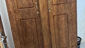 A wooden double door with a brass handle and a keyhole.