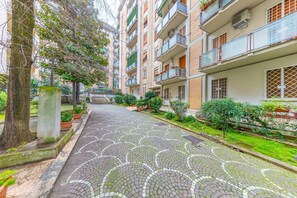 A residential street with a paved walkway, trees, and multi-story buildings with balconies. - Comfort, Relaxation, and a Jacuzzi Just a Stone's Throw from the Heart of Rome (Roma)