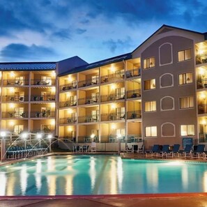 Un hotel de varios pisos con balcones y una piscina.
