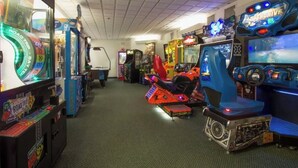 An arcade with various gaming machines, including a motorcycle simulator and racing games. - 2-bedroom 2-story renovated unit at The Cove Resort, park and walk downtown! (Lake Geneva)