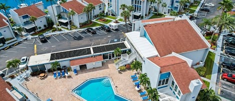 Ein Hotel mit Pool, einer Marina mit Booten und einem Parkplatz.