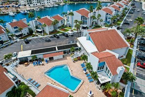 Ein Hotel mit Pool, einer Marina mit Booten und einem Parkplatz.