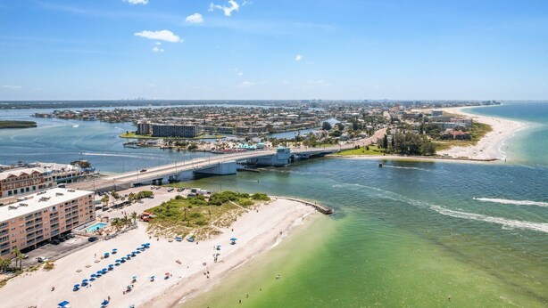 A coastal cityscape with a prominent bridge, beachfront, and a marina. - Beach Front 3 Bedroom - Beach Place #507 (Madeira Beach)