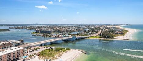 Eine Küstenstadt mit einer markanten Brücke, Strand und einem Yachthafen.