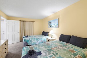 A hotel room with two beds, a painting on the wall, and a lamp on a bedside table. - Beach Front 3 Bedroom - Beach Place #507 (Madeira Beach)