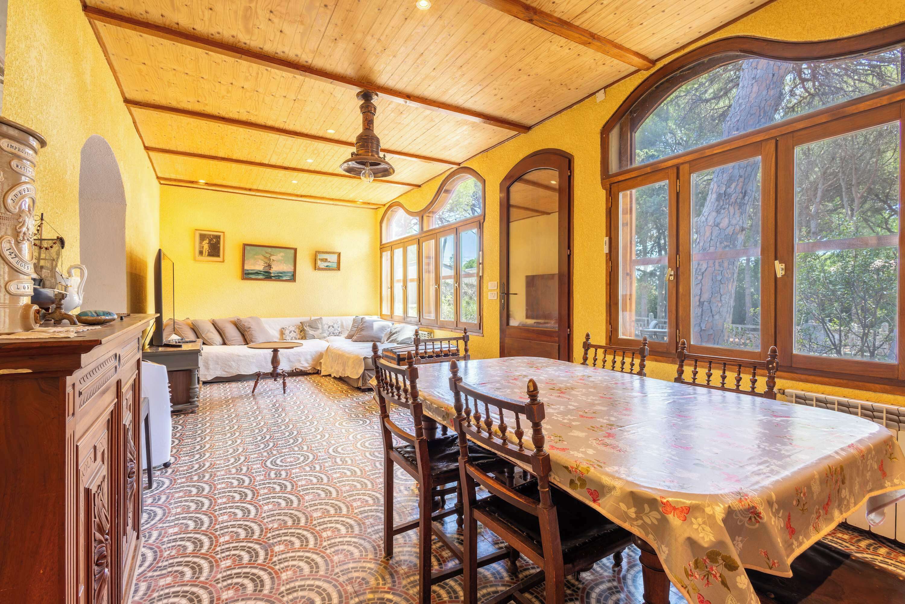A dining area with a large table, chairs, and a patterned floor.