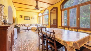 A dining area with a large table, chairs, and a patterned floor. - La villa  des pins (Agde)