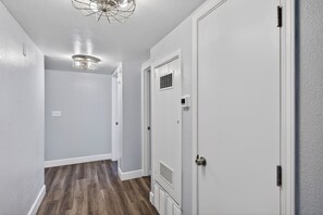 A hallway with white walls, a wooden floor, and a ceiling light fixture. - Family-Friendly Tahoe Home w/ 2 Living Rooms, 3BR, Pack n Play, Near Heavenly Skiing (South Lake Tahoe)
