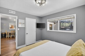 A bedroom with a bed, a window with a view, a door, and a television on the wall. - Family-Friendly Tahoe Home w/ 2 Living Rooms, 3BR, Pack n Play, Near Heavenly Skiing (South Lake Tahoe)