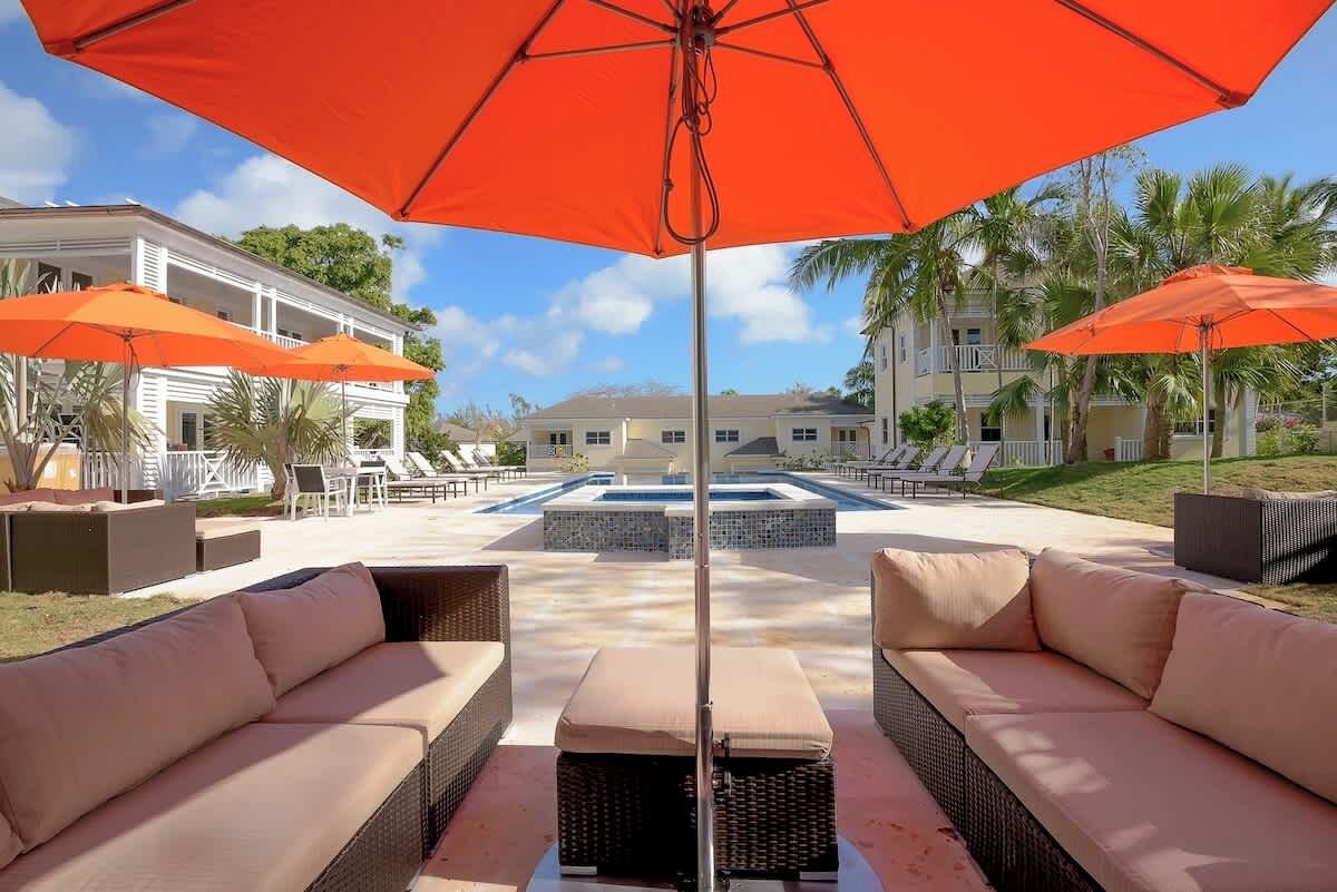 A pool area with outdoor seating and umbrellas.