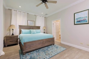 A bedroom with a bed, nightstands, a ceiling fan, a door, and a painting on the wall. - 4 BR w/ 6 Beds Near Atlantis (Nassau)