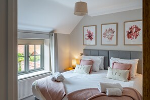 A hotel room with a large bed, a window with a view, and three framed botanical prints on the wall. - Pebbles, Thornham, Norfolk (Thornham)