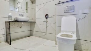 Un baño con un lavamanos blanco, un inodoro y un espejo.