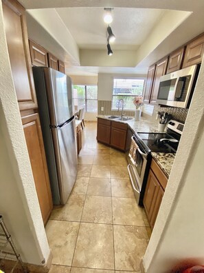A kitchen with a refrigerator, stove, microwave, and sink. - Sweeping views of the Catalina Mountain from this corner 3 bedroom (Tucson)