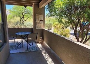 A covered outdoor seating area with a table and chairs, a rug, and a hanging plant. - Sweeping views of the Catalina Mountain from this corner 3 bedroom (Tucson)