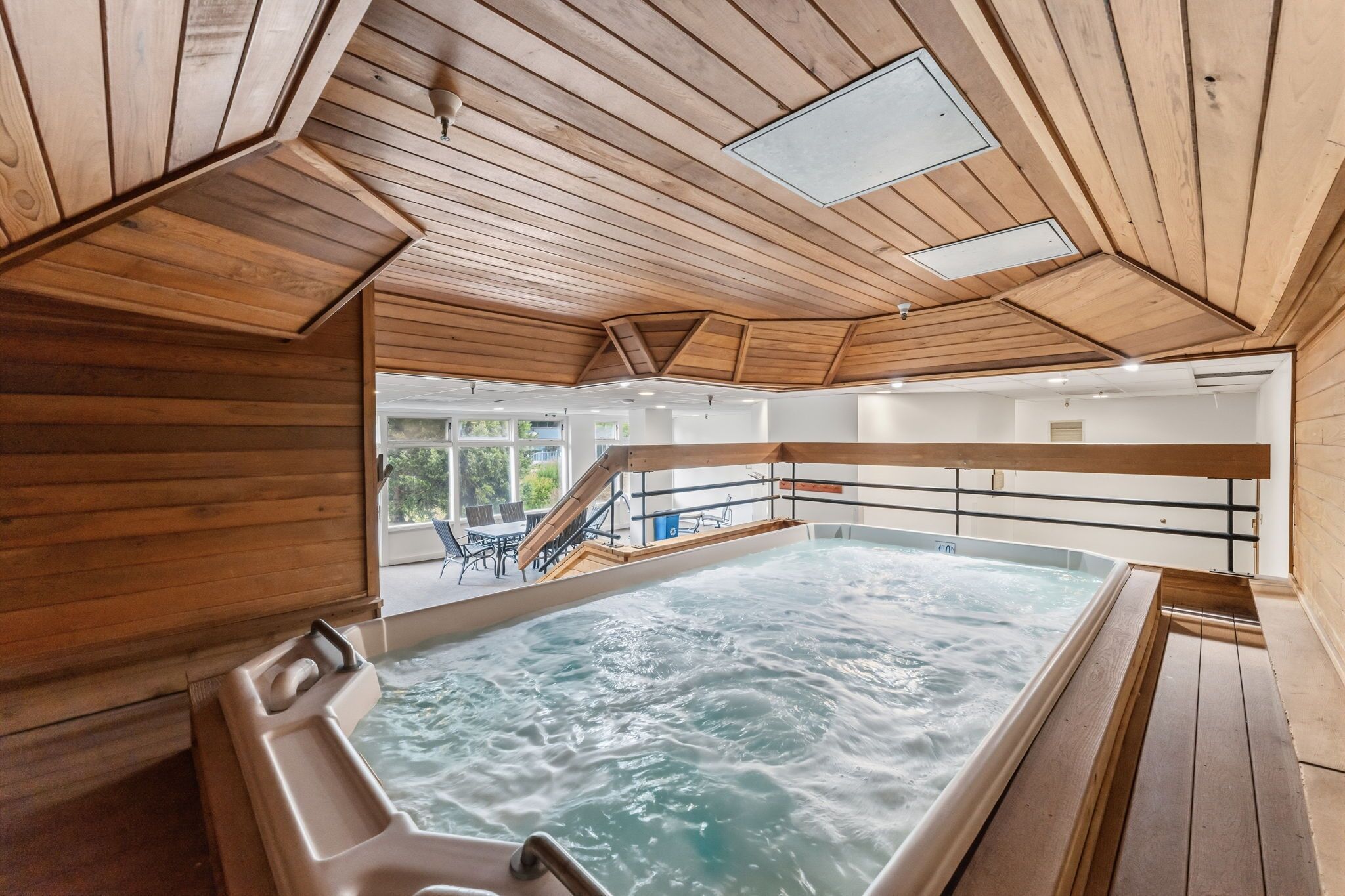 Un jacuzzi en una cabaña de madera con vistas al paisaje.