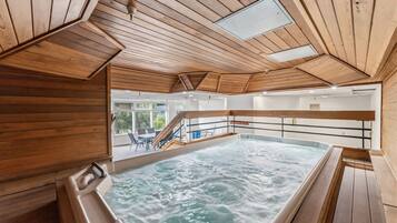 Un jacuzzi en una cabaña de madera con vistas al paisaje.