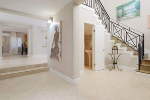 Ein geräumiger Innenraum mit Treppe, Essbereich und Flur zum Badezimmer.