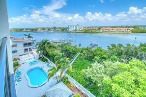 A hotel with a pool, a view of a river, and a distant building. - Two Bedroom/Two Bathroom Direct Intracoastal Condo (Indian Shores)