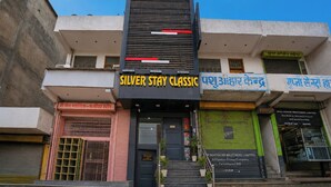 Un immeuble sur lequel on peut voir une enseigne bien visible indiquant le nom de l’hôtel « SILVER STAY CLASSIC ».