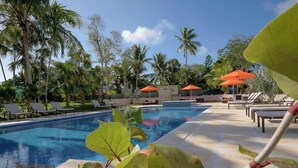 A swimming pool with lounge chairs and umbrellas, surrounded by palm trees. - Fully Equipped 3 BR Villa w/ Easy Beach Access (Nassau)